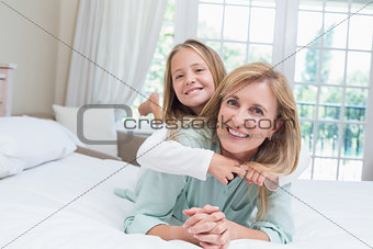 Happy mother and daughter smiling at camera