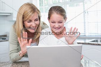 Mother and daughter talking with someone with the laptop