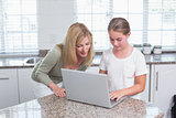Mother and daughter using laptop together