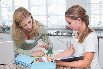 Mother helping daughter doing homework