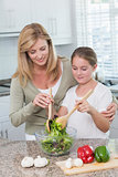 Mother and daughter preparing salad together