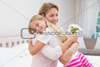 Mother and daughter hugging with flowers