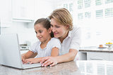 Mother and daughter using laptop