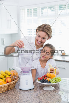 Mother and daughter making a smoothie
