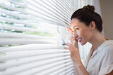 Woman peeking through the blinds