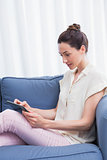 Casual brunette using tablet on couch