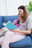 Mother and daughter reading on couch