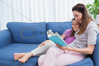 Mother and daughter reading on couch