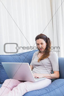 Casual woman using laptop on couch