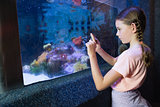 Cute girl looking at fish tank