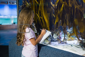 Cute girl looking at fish tank