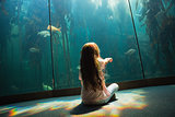 Little girl looking at fish tank