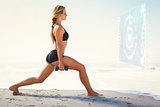 Composite image of fit blonde doing weighted lunges on the beach
