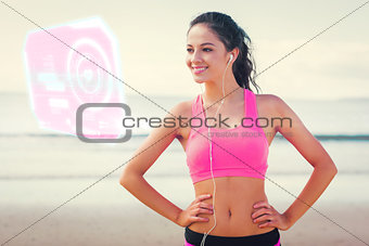 Composite image of beautiful smiling healthy with earphones on beach