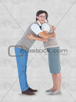 Composite image of geeky hipster couple hugging