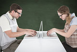 Composite image of geeky hipster couple using laptop