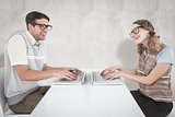 Composite image of geeky hipster couple using laptop