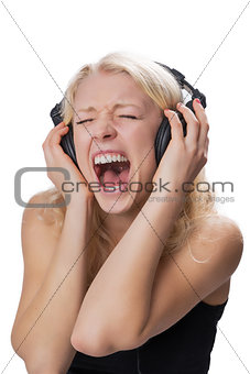 Young blond girl wearing headphones, screaming