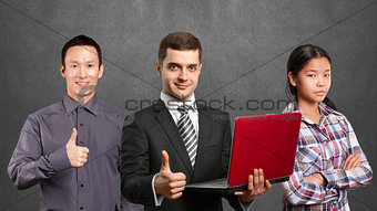 Asian team and male in suit with laptop in his hands
