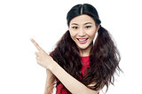 Smiling chinese girl pointing away