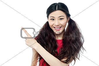 Smiling chinese girl pointing away