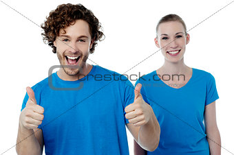 Cheerful couple holding thumbs up