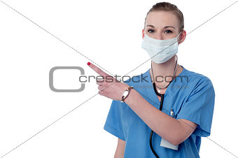 Young smiling doctor pointing copy space