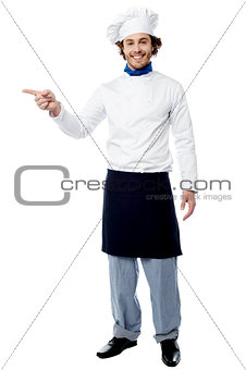 Young male chef pointing to a product