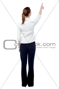 Young business woman pointing at wall