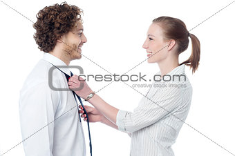 Young woman adjusting her husband's tie