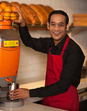 Cheerful chef making fresh orange juice