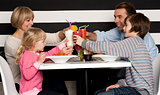 Family toasting smoothies in restaurant