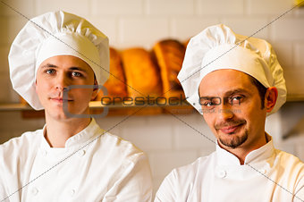 Young smiling chefs posing in bakery