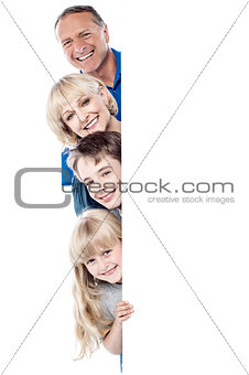 Family of four behind blank whiteboard