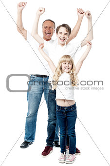 Excited family with arms up