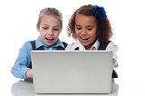 Little girls playing games on laptop