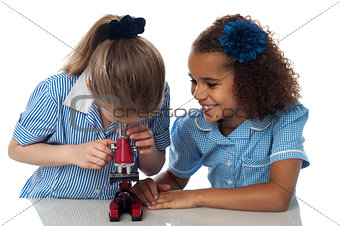 Little girls looking into microscope