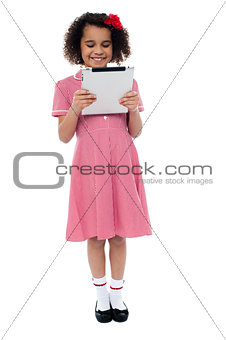 Smiling child busy with tablet pc