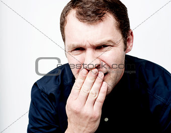 Handsome man covering his mouth with hand