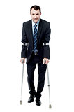 Businessman walking with crutches