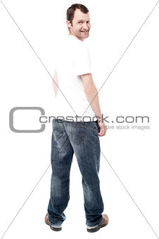 Handsome man in jeans standing back