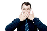 Businessman covering his mouth with hands
