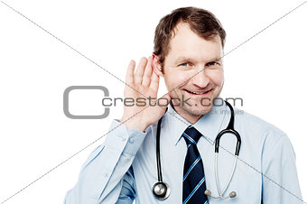 Physician listening with his hand on an ear