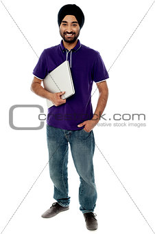Cheerful young man holding laptop