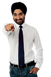 Smiling businessman pointing towards you
