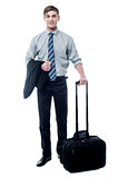 Young businessman posing with trolley bag