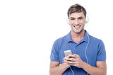 Young man enjoying music from his cell phone