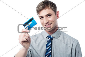 Smiling corporate guy showing his debit card