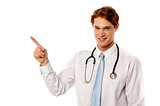 Smiling male physician pointing away