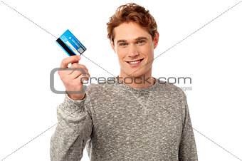 Smiling young man holding credit card